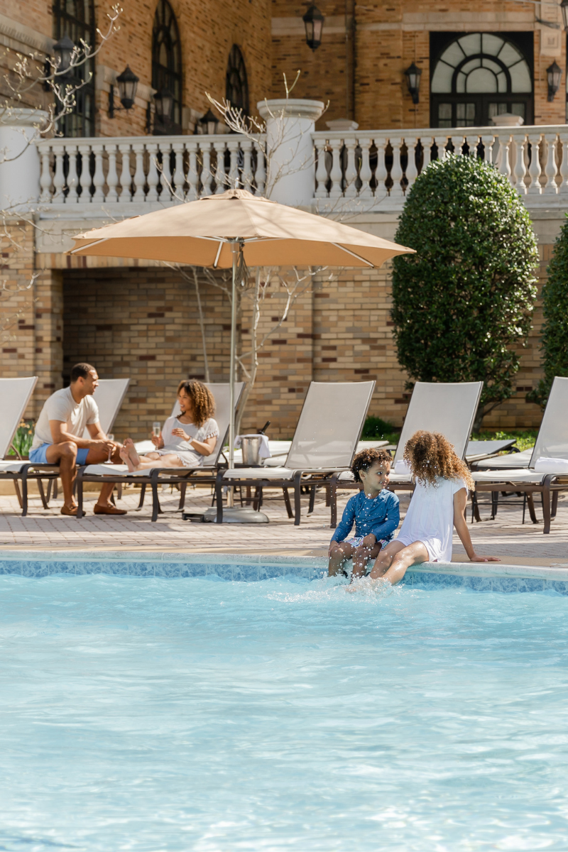 Family lounging at outdoor pool at Omni Shoreham Hotel