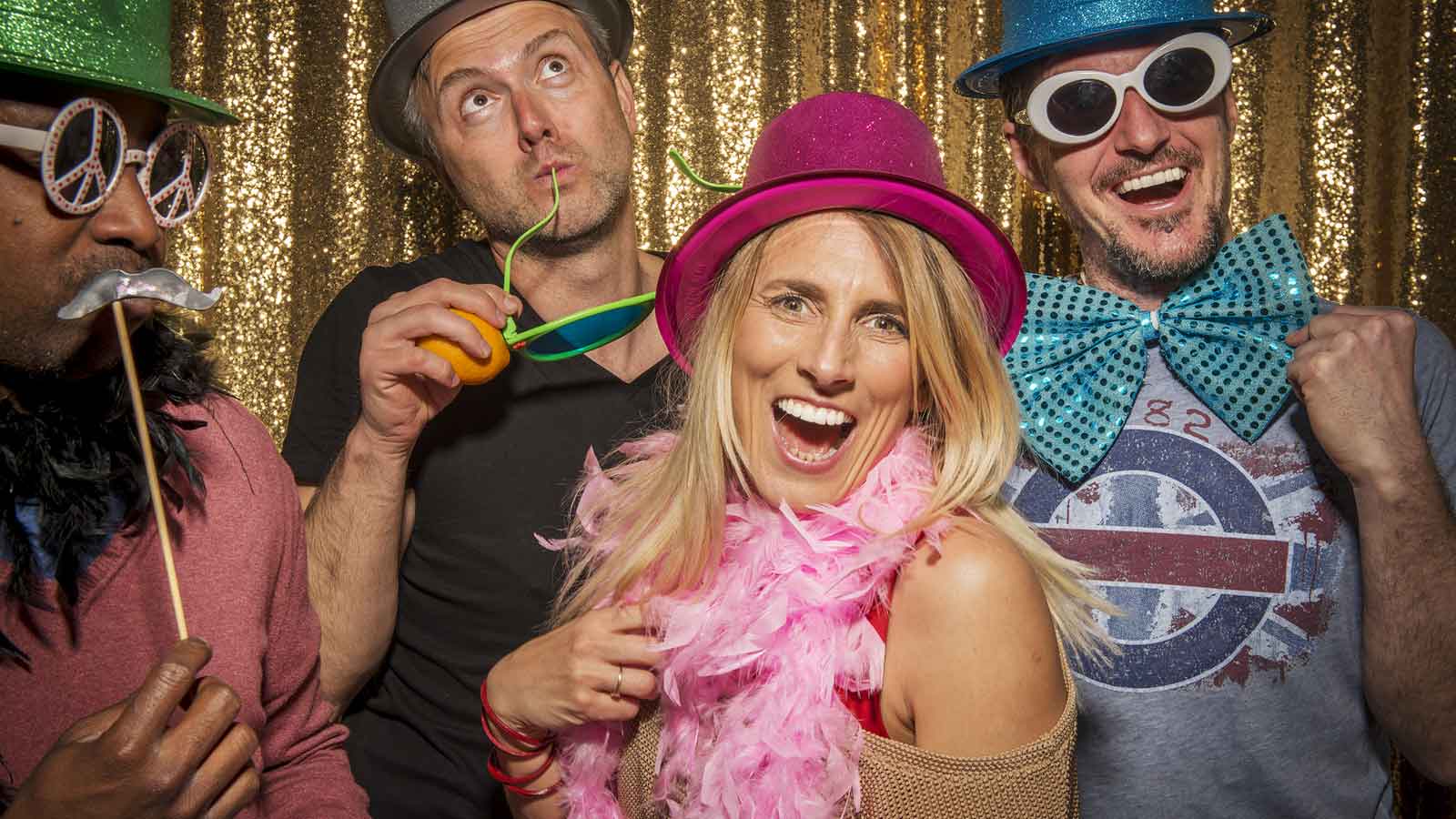 People posing with props in a photo booth