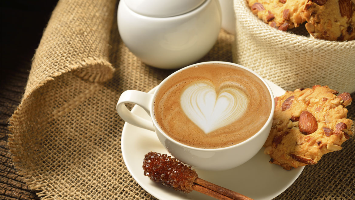 Coffee with heart pattern and biscuits