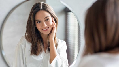 Woman looking at her reflection in the mirror