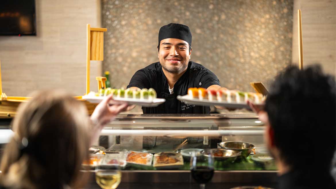 Chef serving sushi dishes