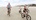 Family riding bikes on the beach