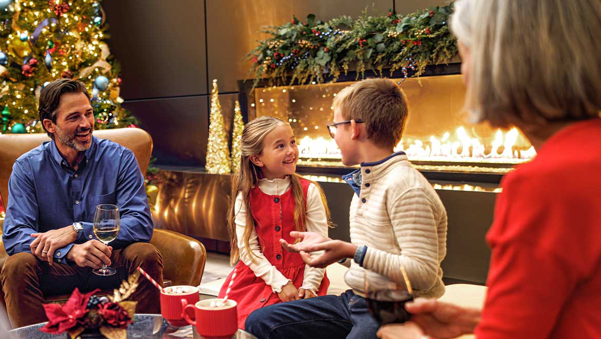 Family having hot cocoa by the fireplace